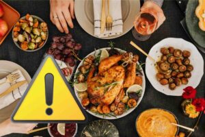 una tavola con tanti alimenti diversi ed il simbolo attenzione