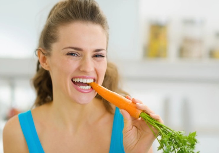 donna che mangia una carota cruda