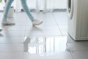 gambe di ragazza vicino ad acqua accanto alla lavatrice